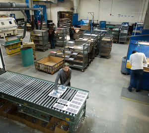 Bird's eye view of the manufacturing facility with people working on registers.